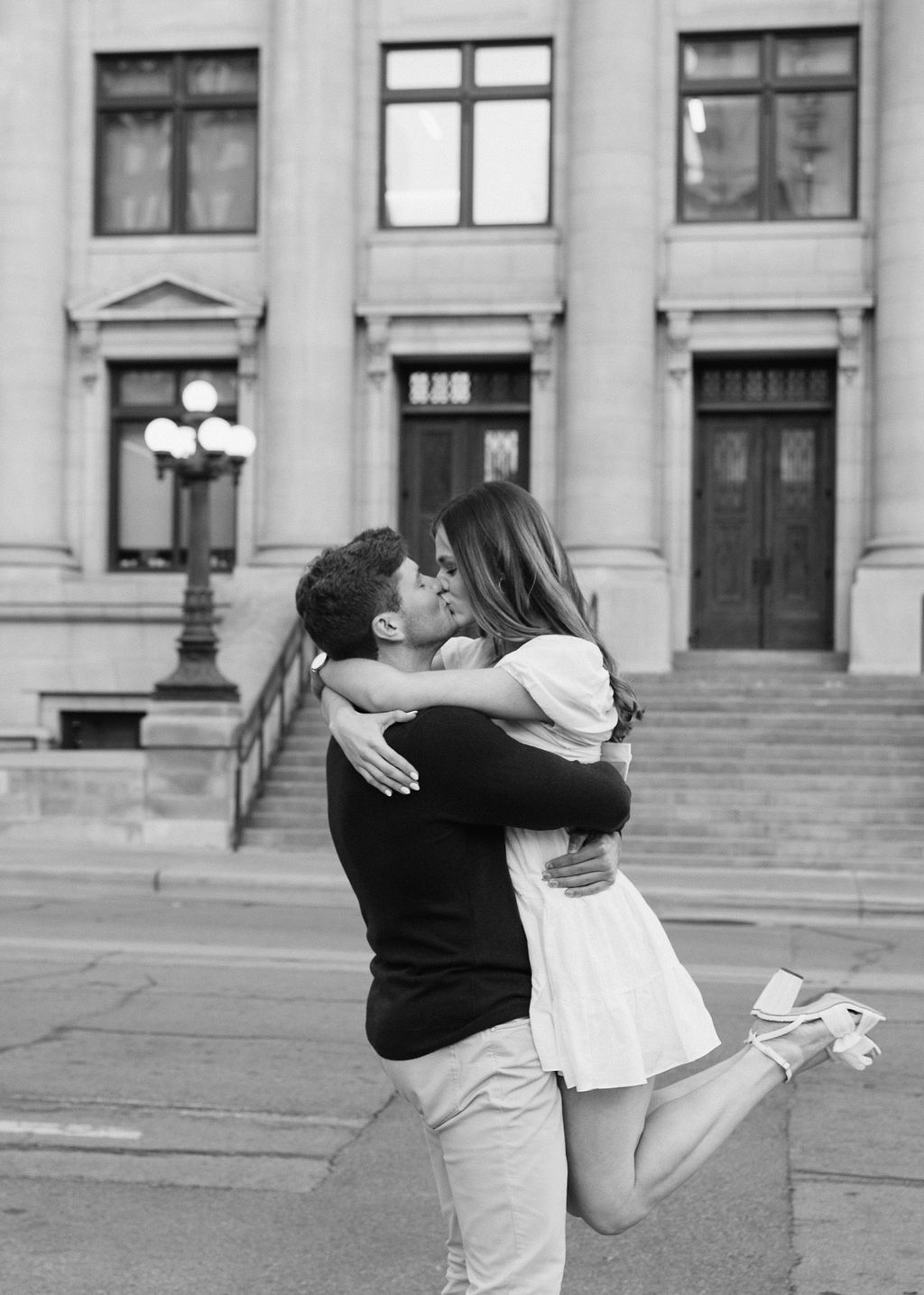 Black and white image of a bride and groom in Downtown Dallas taking engagement photos